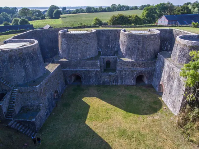 Vue aérienne d'une forteresse en pierre avec des murs épais et des tours rondes