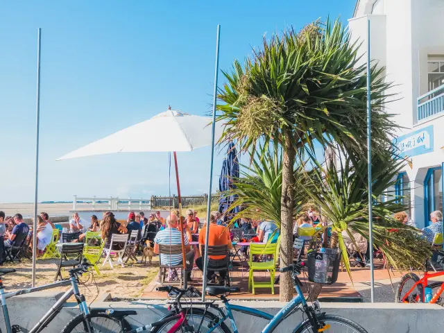 Trois vélos garés près d'une terrasse en bord de mer