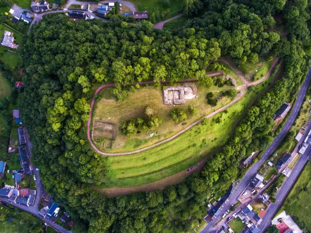 Aerial view of a wooded hill with trails and stone structures