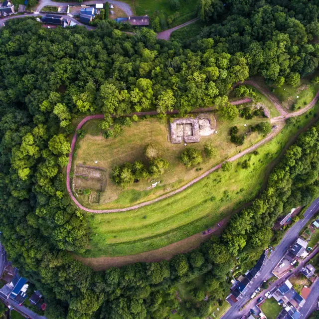 Aerial view of a wooded hill with trails and stone structures