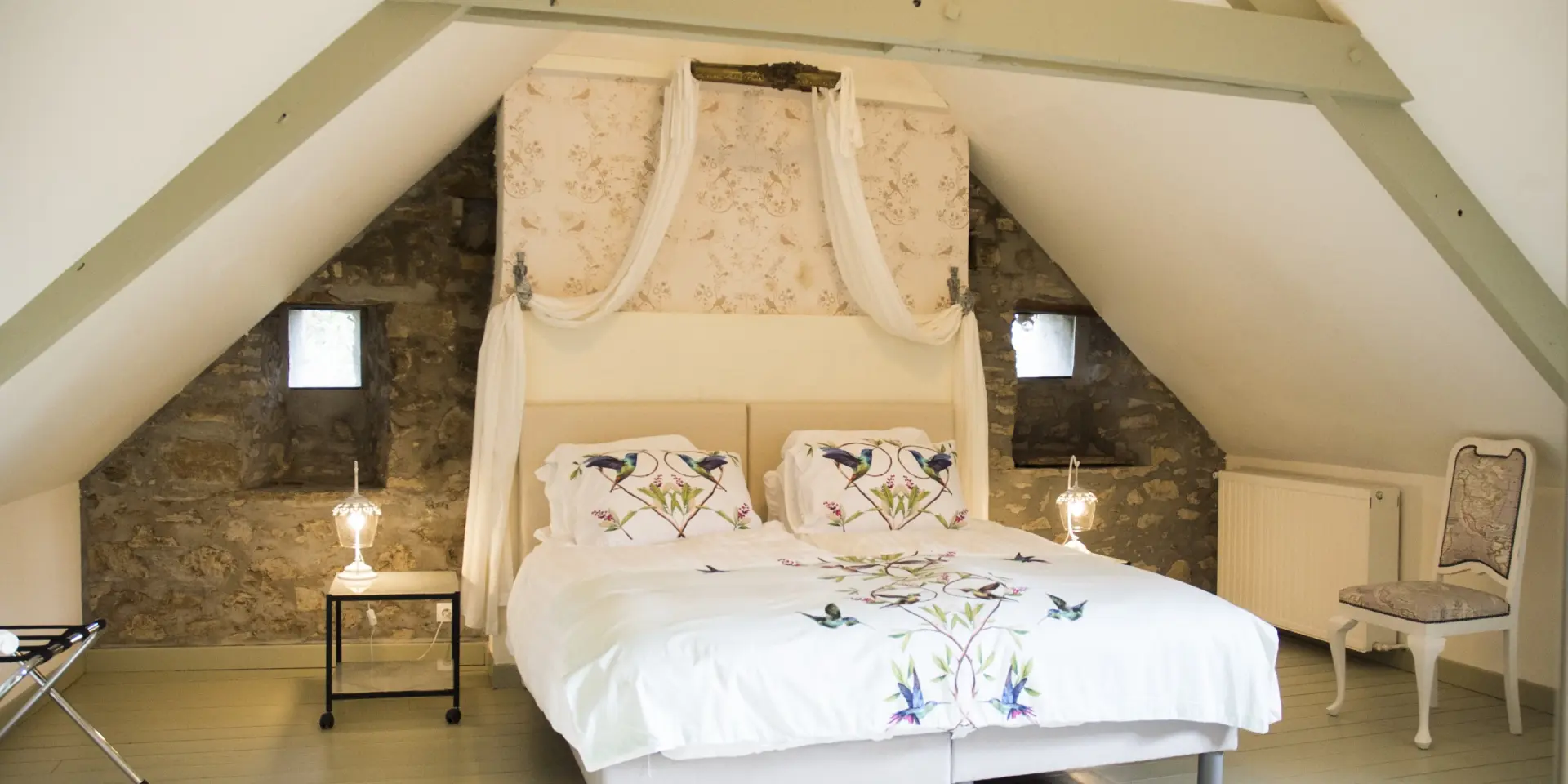 Chambre à coucher avec un grand lit à baldaquin et des murs en pierre apparente