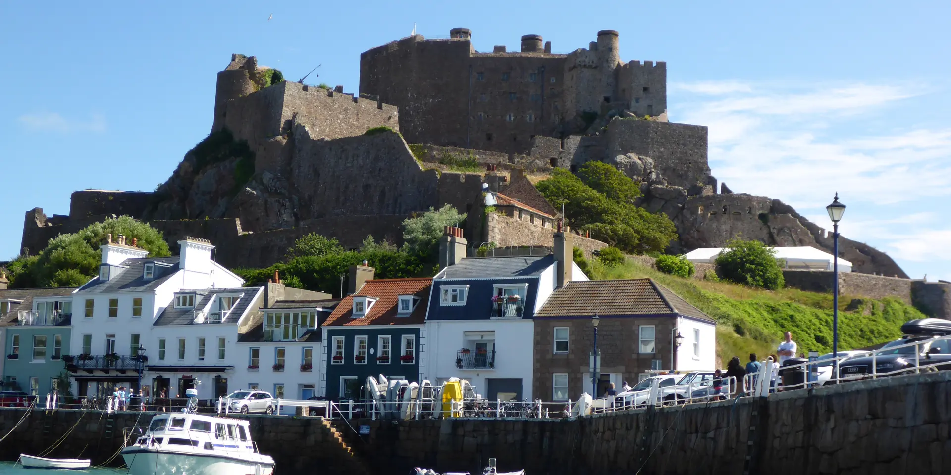 Steinburg auf einem Hügel über einem Hafen mit festgemachten Booten
