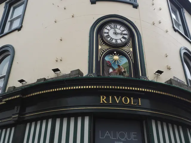 Fassade eines Geschäfts mit einer Uhr und einem Rivoli-Schild