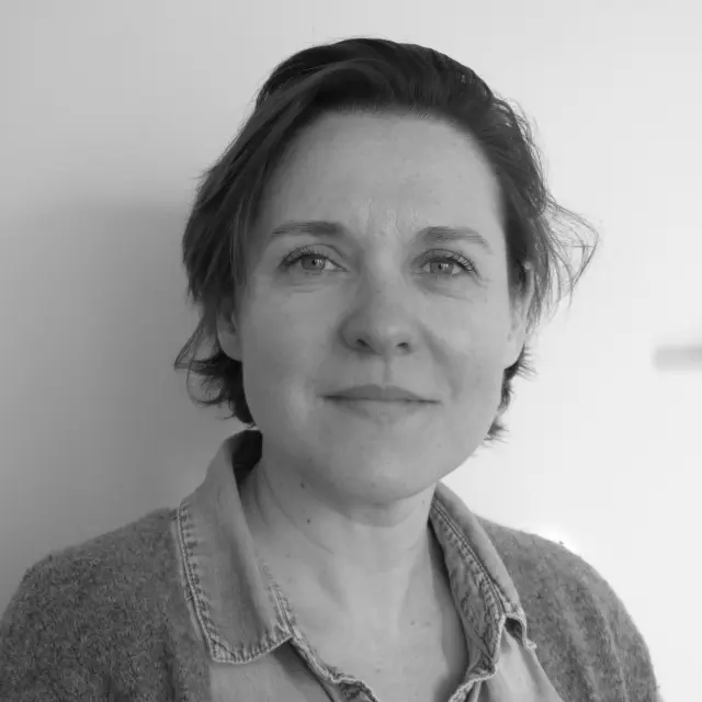 Porträt einer Frau mit kurzen Haaren und einem karierten Hemd