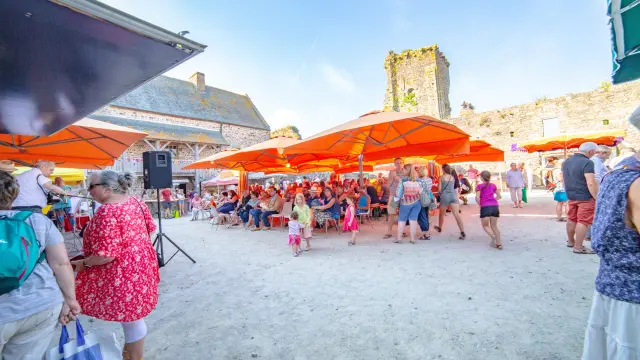 Fête de village avec des tentes orange et des gens en train de danser