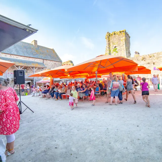 Dorffest mit orangen Zelten und tanzenden Menschen