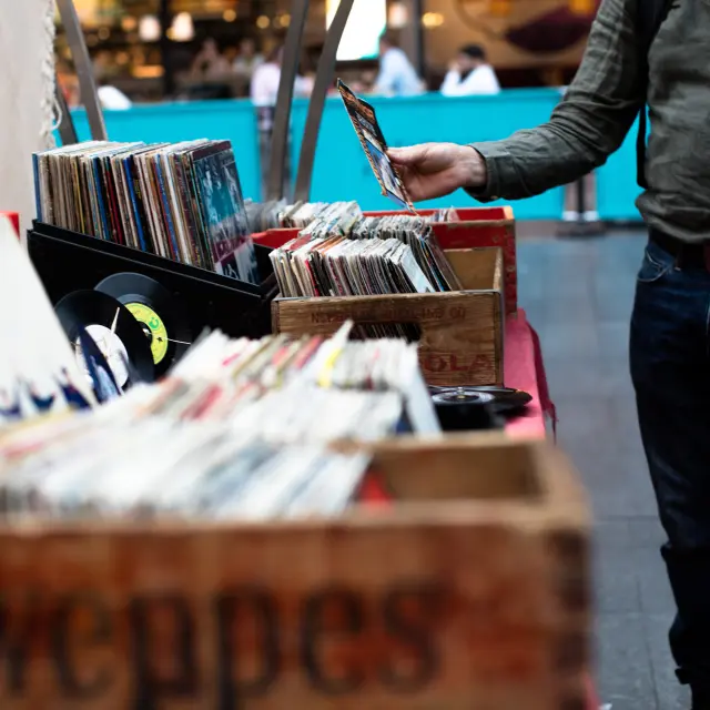 Personne feuilletant des disques vinyles dans un marché de disques vintage