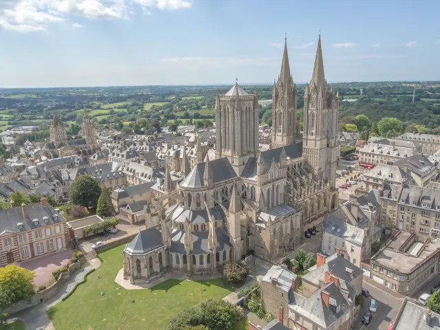 Cathédrale gothique avec deux tours pointues et des bâtiments anciens en contrebas