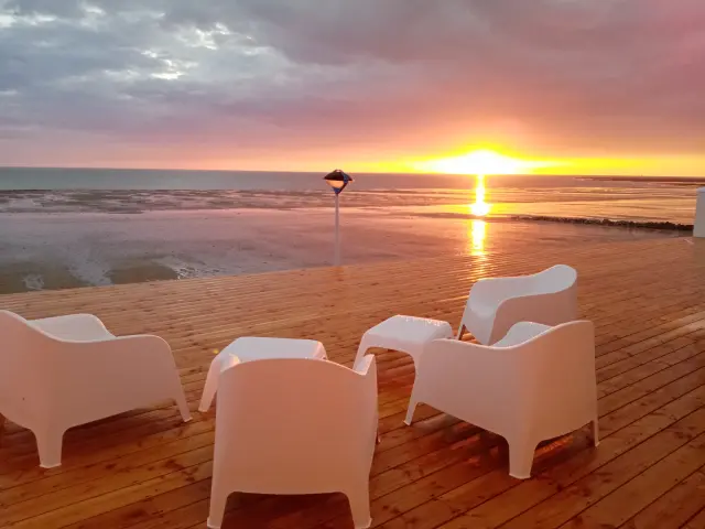 Terrasses de café vides au coucher du soleil avec des chaises et tables en bois