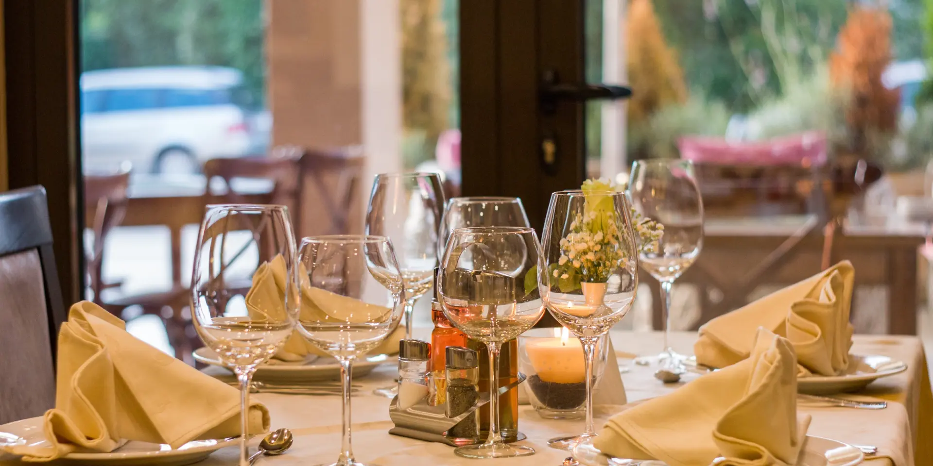 Table dressée avec des verres à vin, des serviettes en tissu et des couverts
