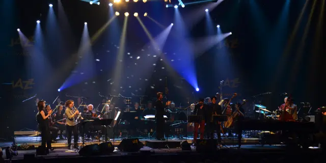 Orchester spielt auf der Bühne mit hellen Scheinwerfern