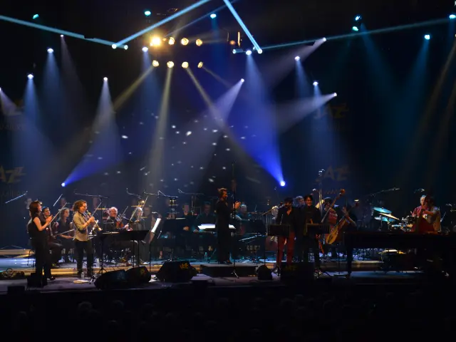 Orchester spielt auf der Bühne mit hellen Scheinwerfern