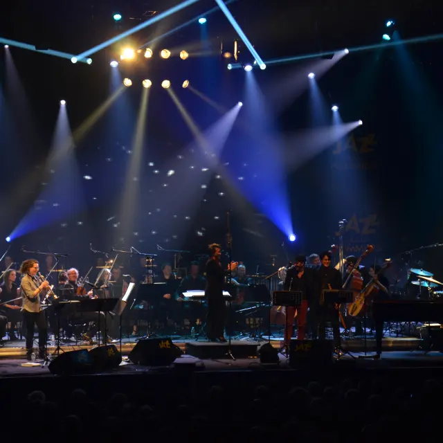 Orchestre jouant sur scène avec des projecteurs lumineux