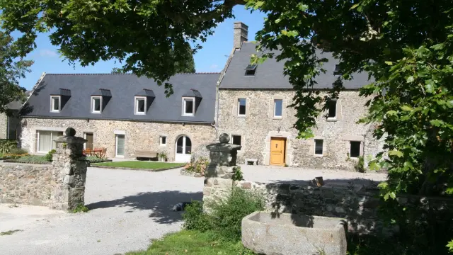 Grande maison en pierre avec un jardin et une fontaine