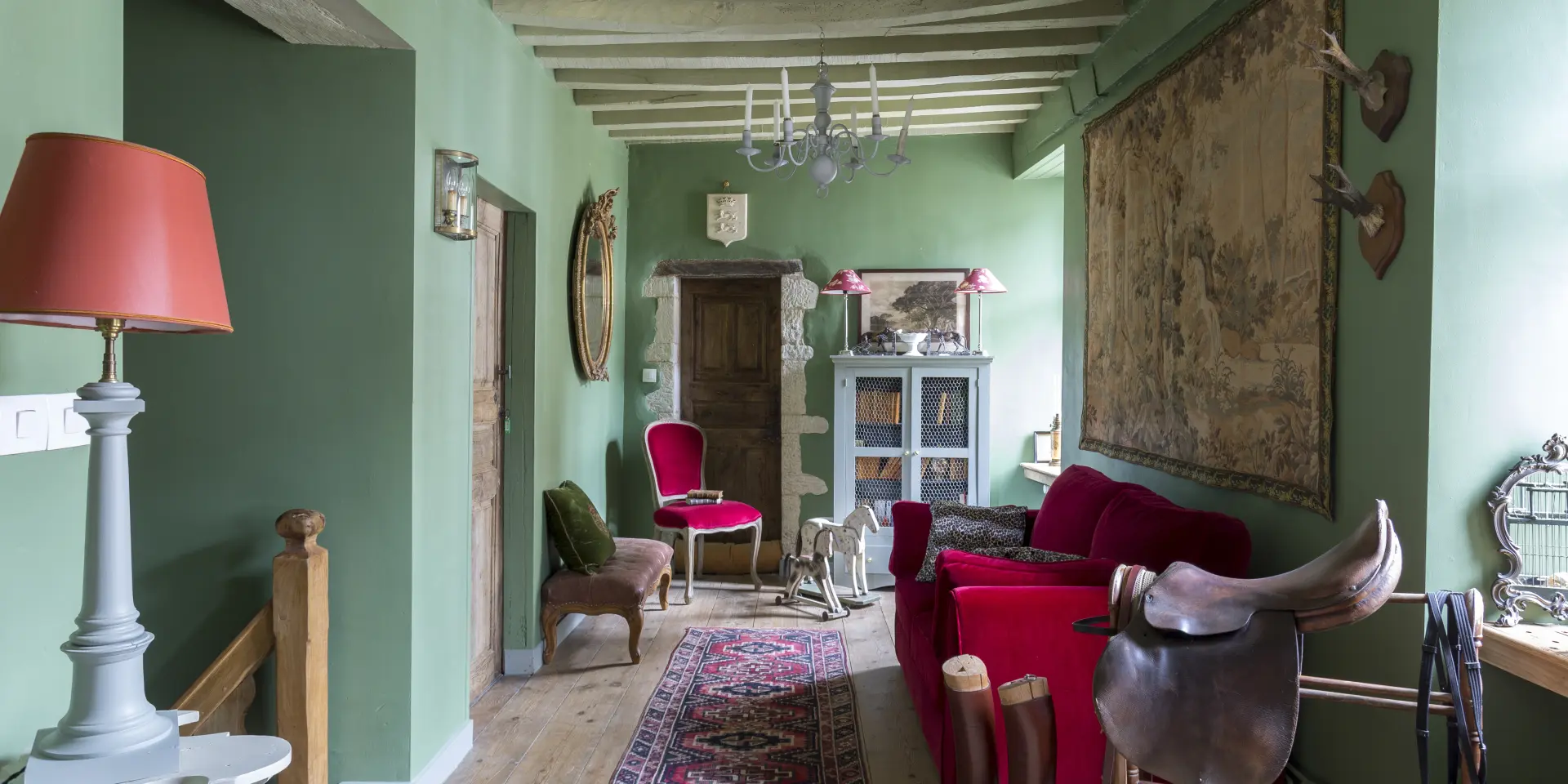 Living room with green walls, a red sofa, and various decorative accessories