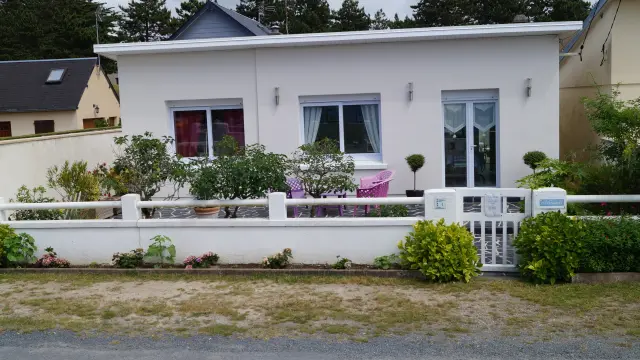 Maison blanche avec jardin fleuri et clôture blanche