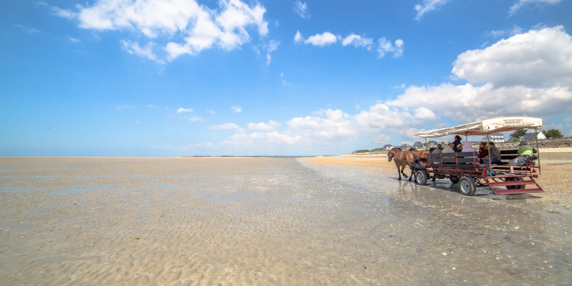 Dune buggy carrying passengers on a sandy beach