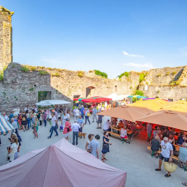 Lively market in a fortress with colorful stalls and visitors