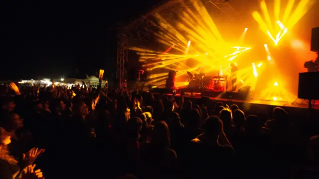 Crowd attending a concert with bright spotlights
