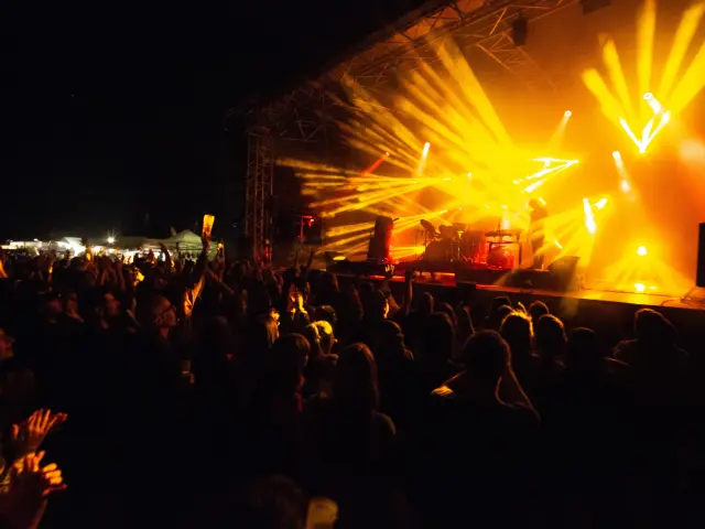 Crowd attending a concert with bright spotlights