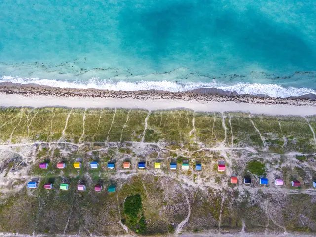 White sandy beach with colorful beach huts and turquoise sea
