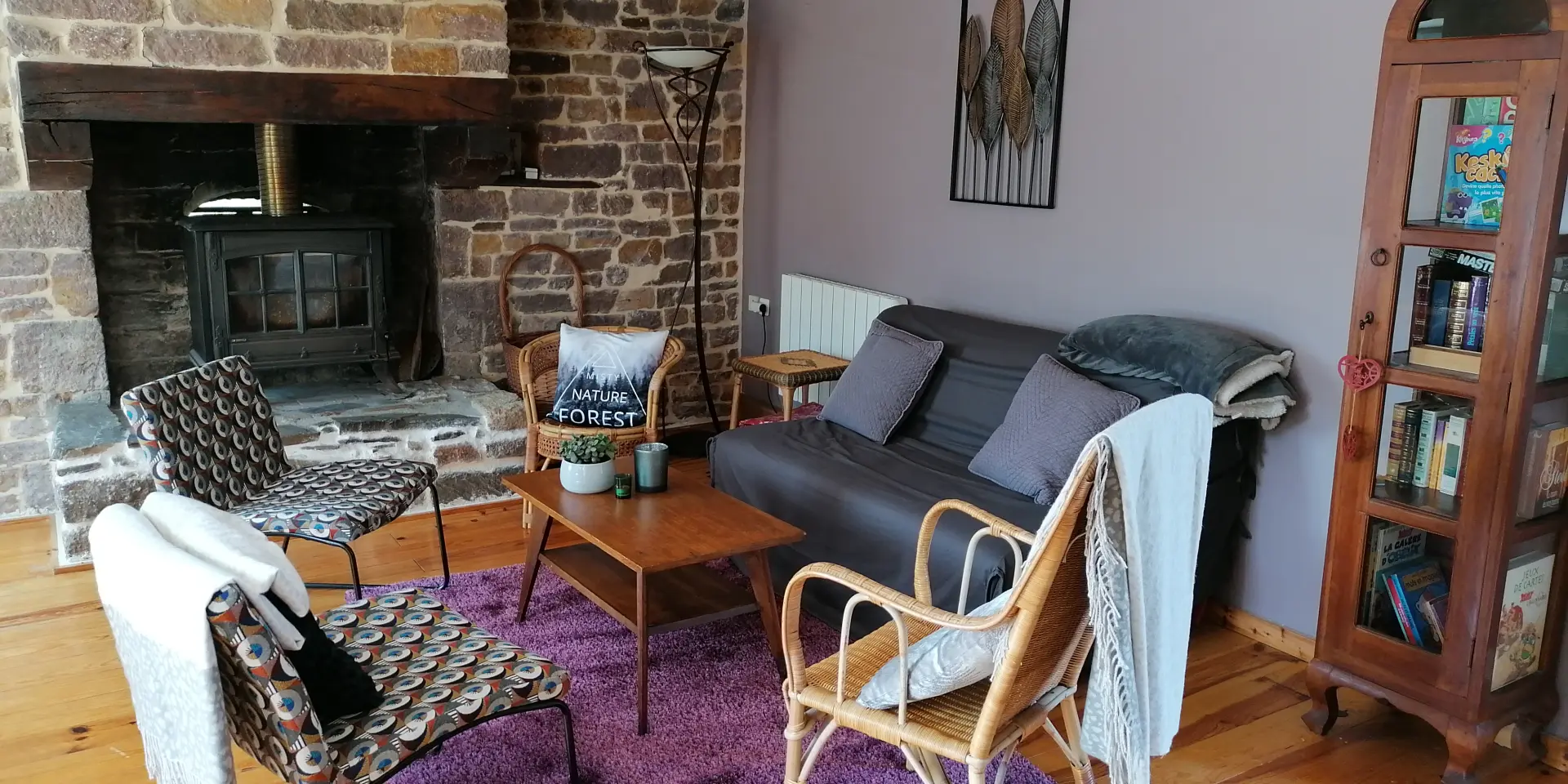 Wohnzimmer mit Sofa, Stühlen, Stein-Kamin und Bücherregal