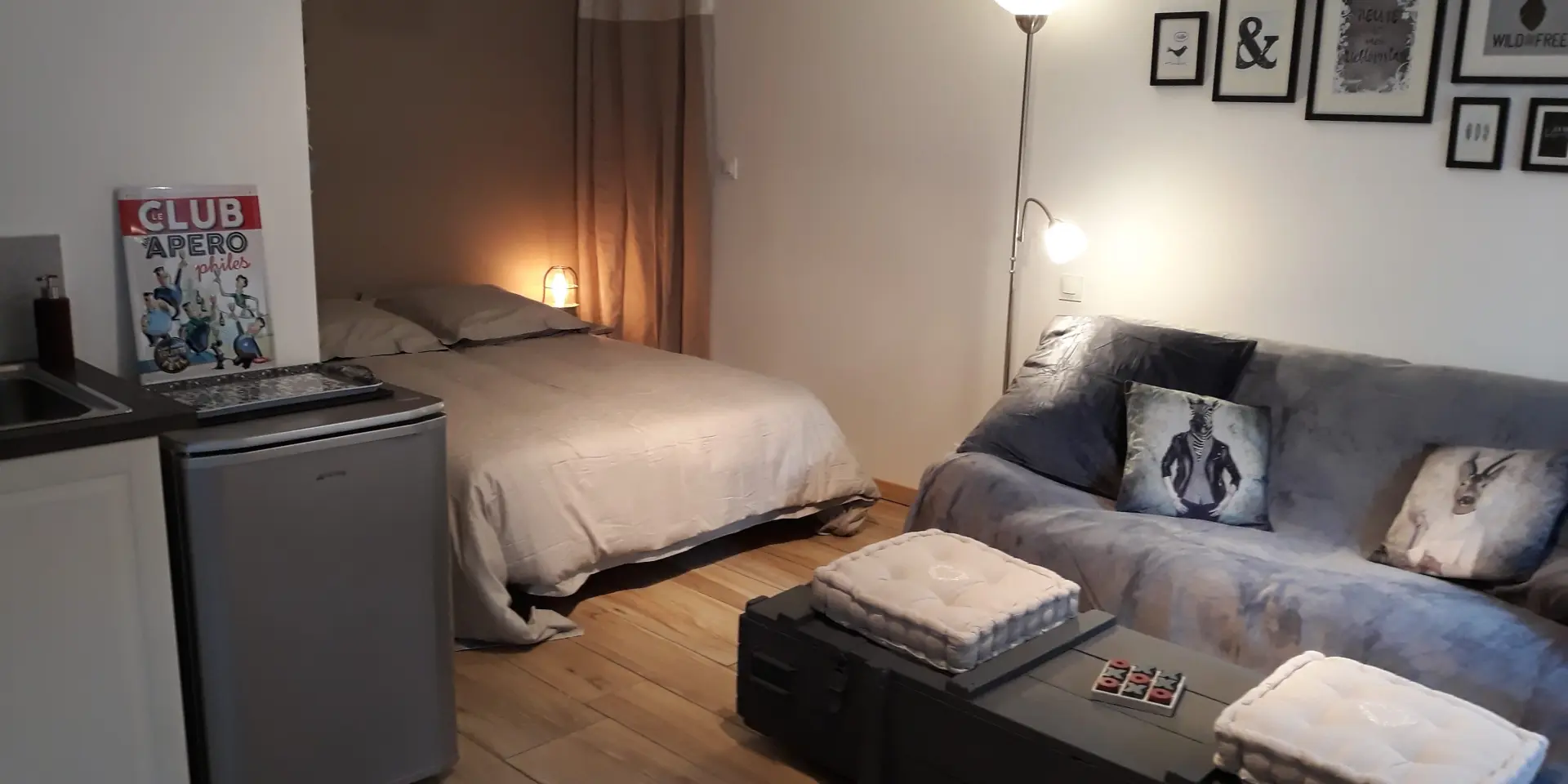 Chambre d'hôtel avec lit double, table de chevet, miroir et étagères murales