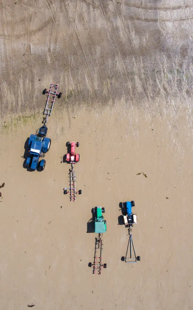 Tracteurs et remorques sur le sable vus du ciel