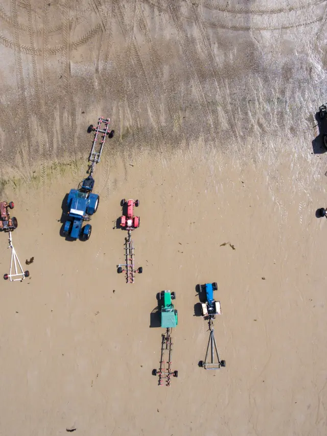 Tracteurs et remorques sur le sable vus du ciel