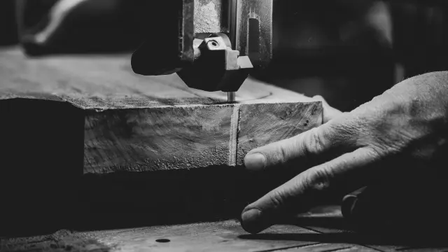 Un artisan utilise une machine pour sculpter une pièce de bois