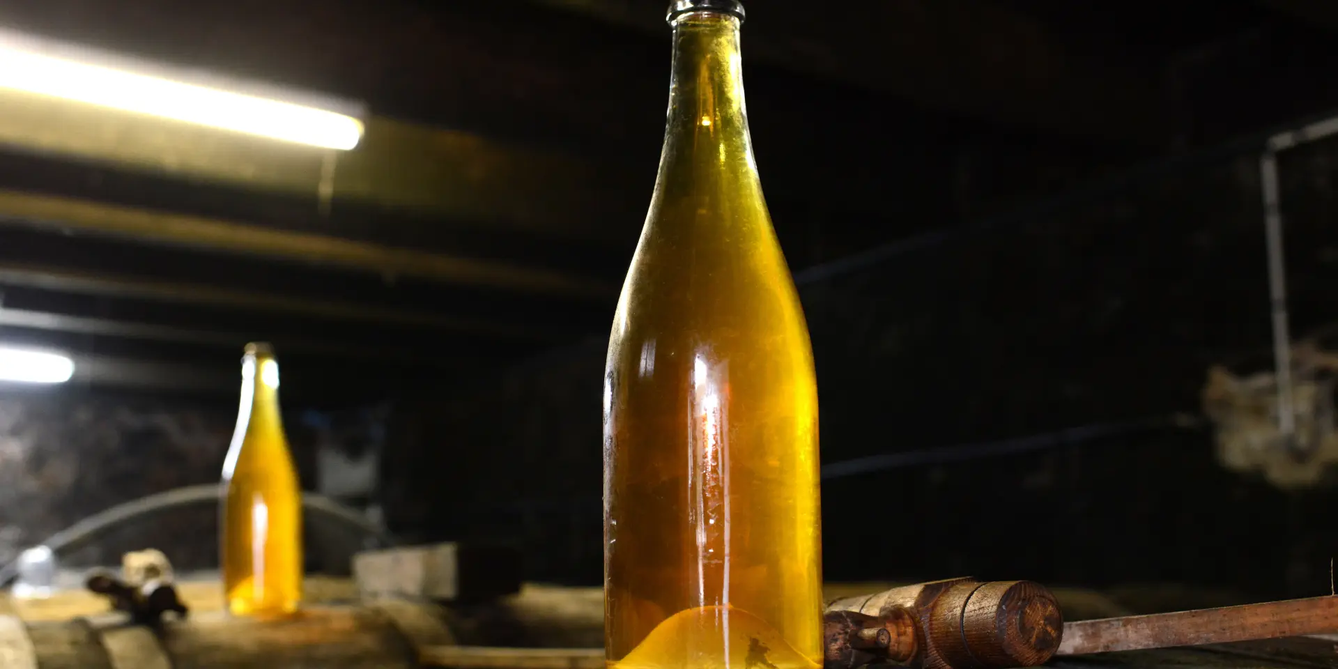 Two bottles of artisanal beer on a wooden barrel
