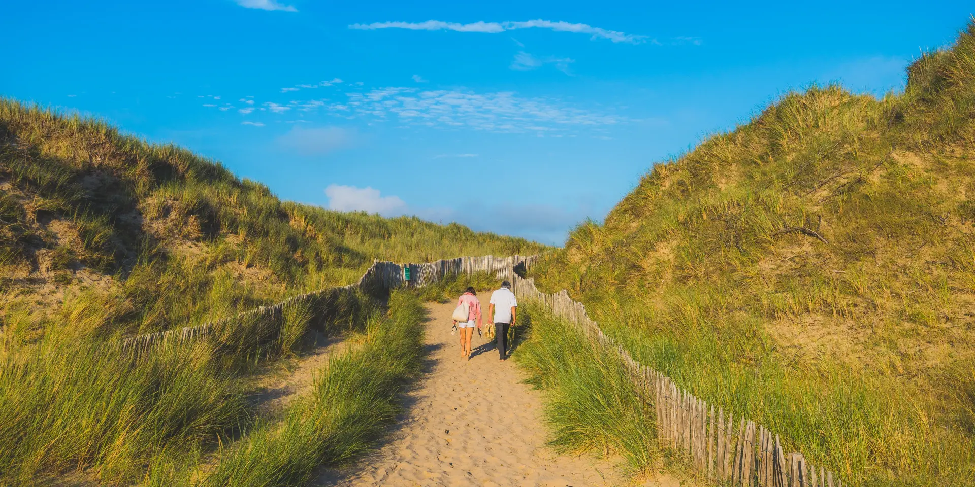 Deux personnes marchant dans les dunes de Annoville