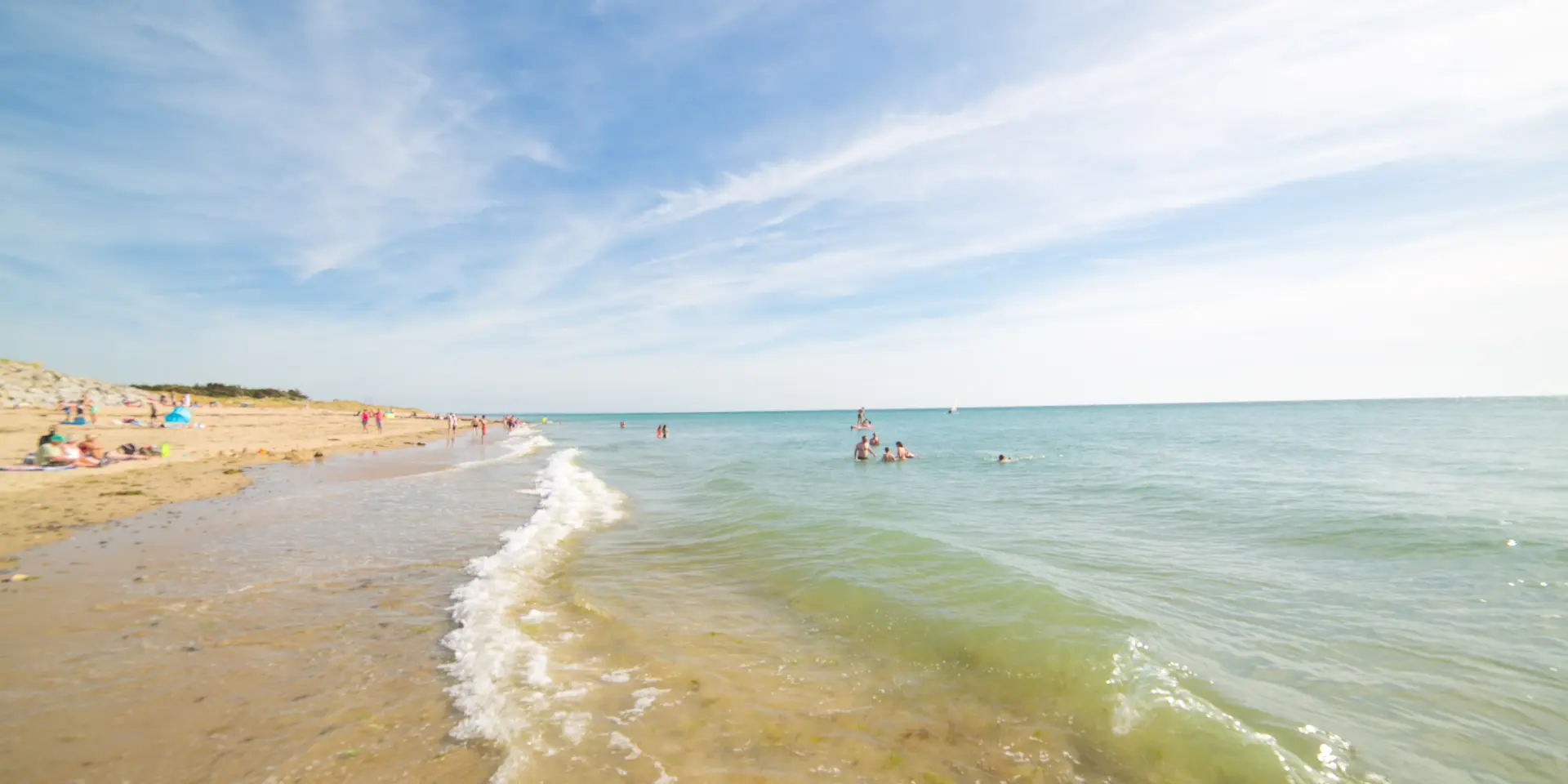People swimming and relaxing on a sandy beach