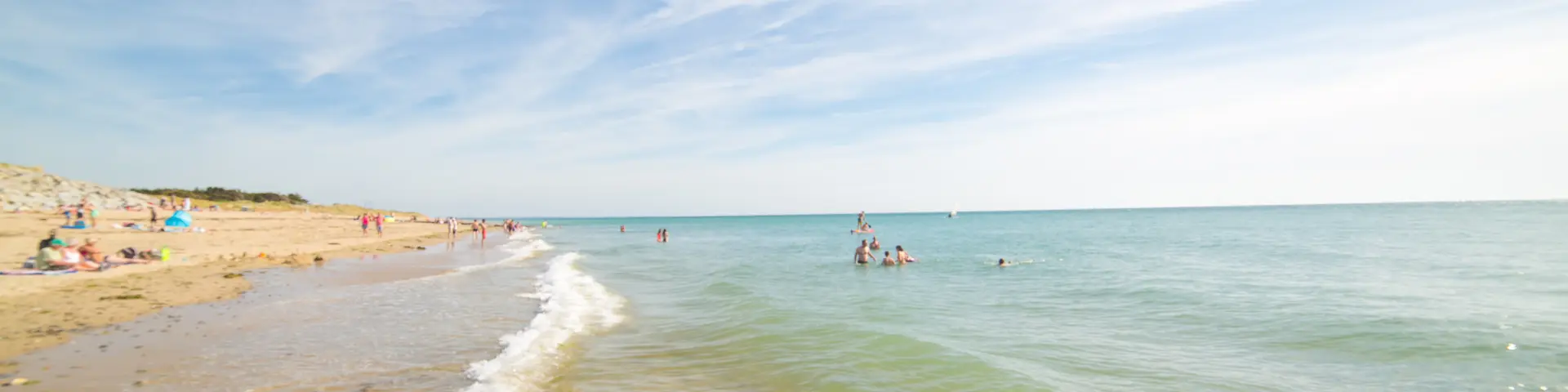 Personnes se baignant et se relaxant sur une plage de sable