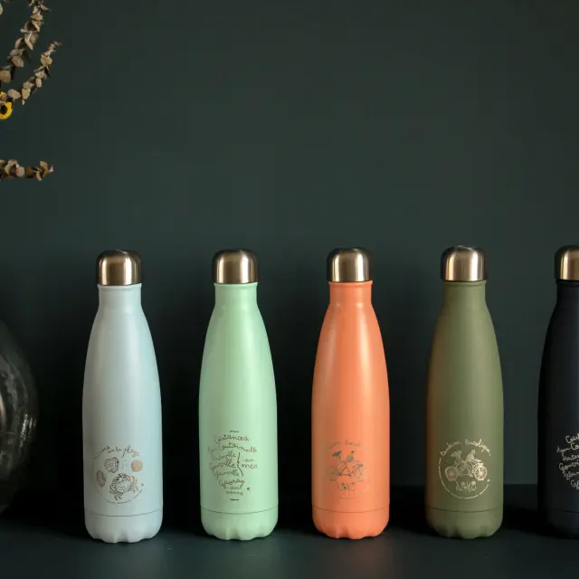 Cinq flacons de parfum de différentes couleurs alignés sur une surface noire