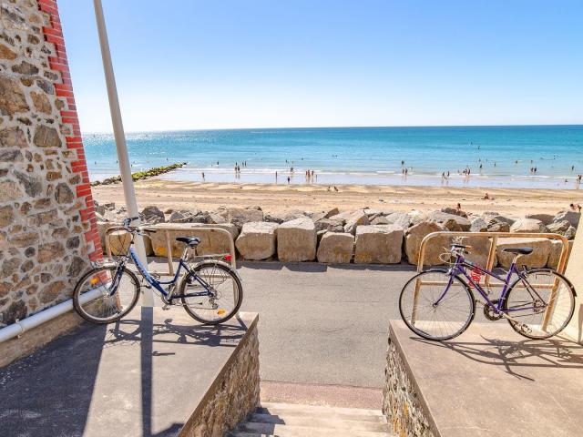 Deux vélos garés près d'une plage avec des gens nageant dans l'eau