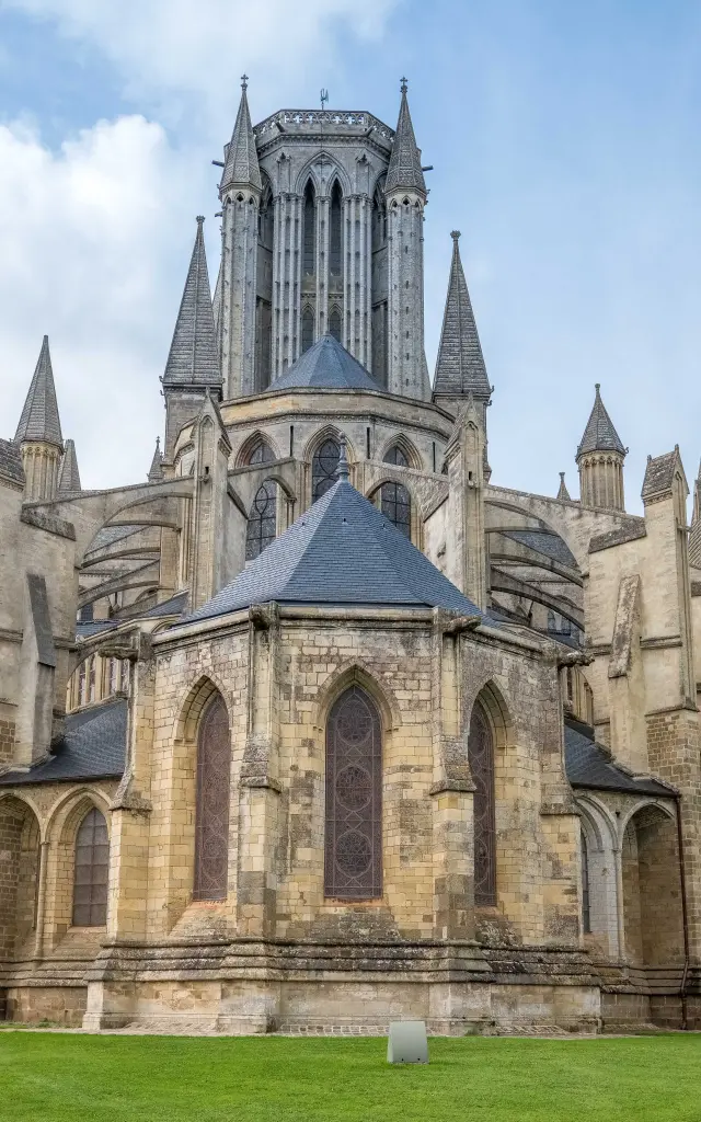 Facade of a Gothic cathedral in grey stone with stained glass and flying buttresses