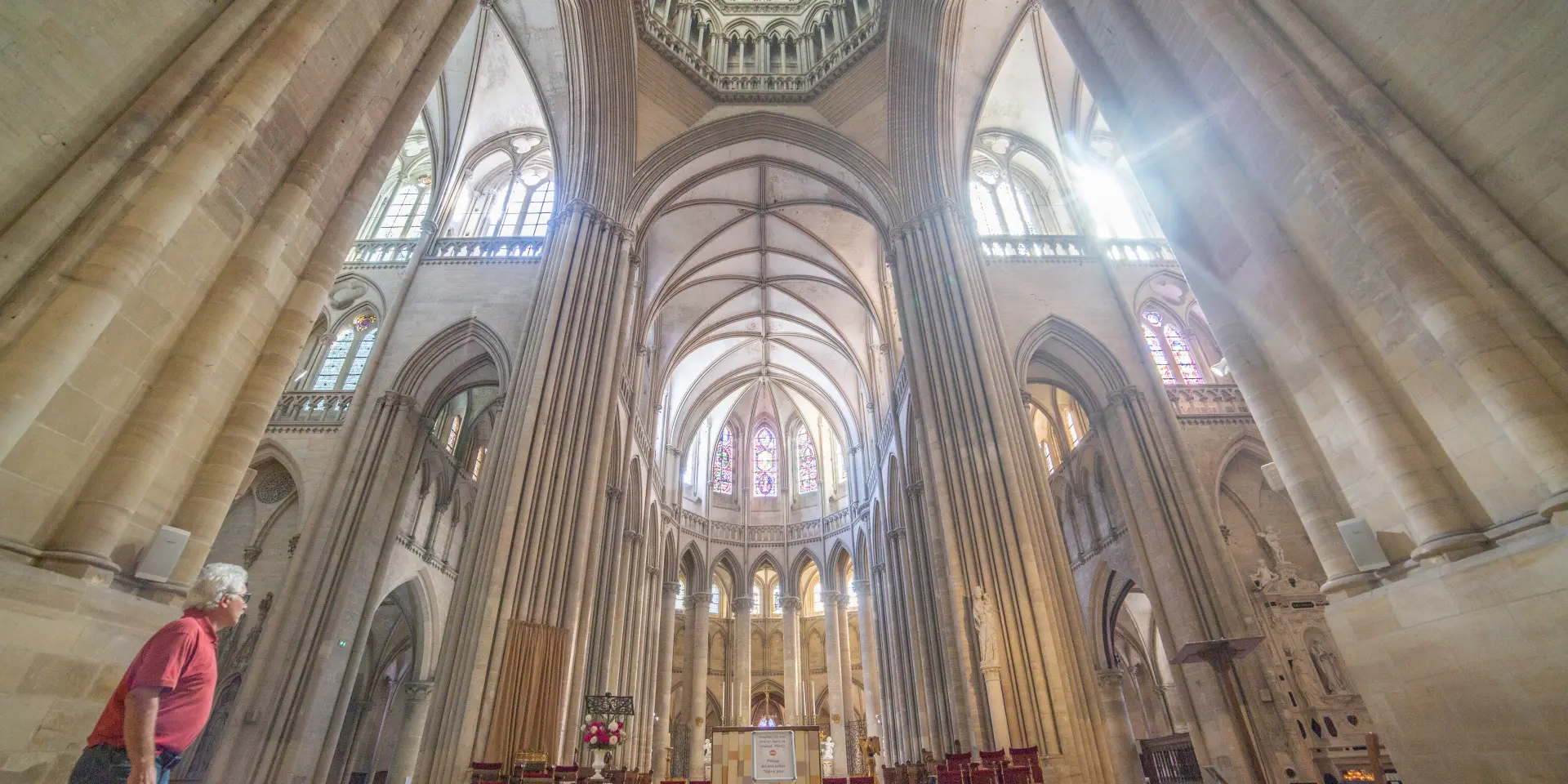 Central nave of a Gothic cathedral with ribbed vaults and stained-glass windows