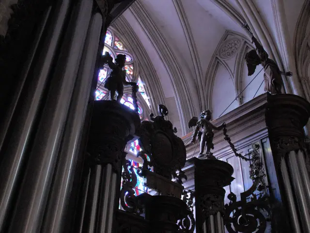 Intérieur d’une église gothique avec une voûte en ogive et un lustre suspendu orné de bougies