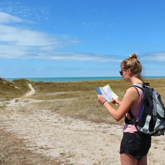 A woman hiking looks at a map outdoors