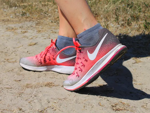 Pieds portant des chaussures de sport rouges et grises avec des chaussettes grises