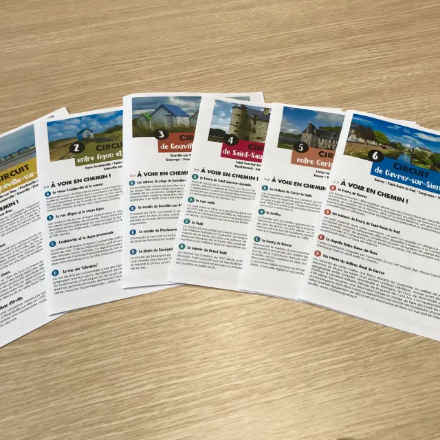 Six tourist brochures in French on a wooden table