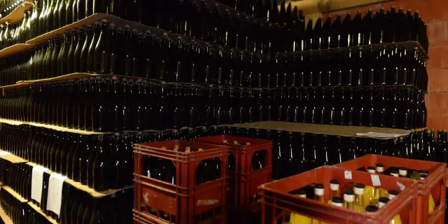 Rayonnages remplis de bouteilles de cidre et de caisses de bouteilles