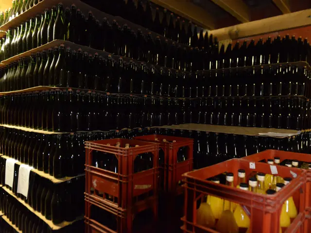 Rayonnages remplis de bouteilles de cidre et de caisses de bouteilles