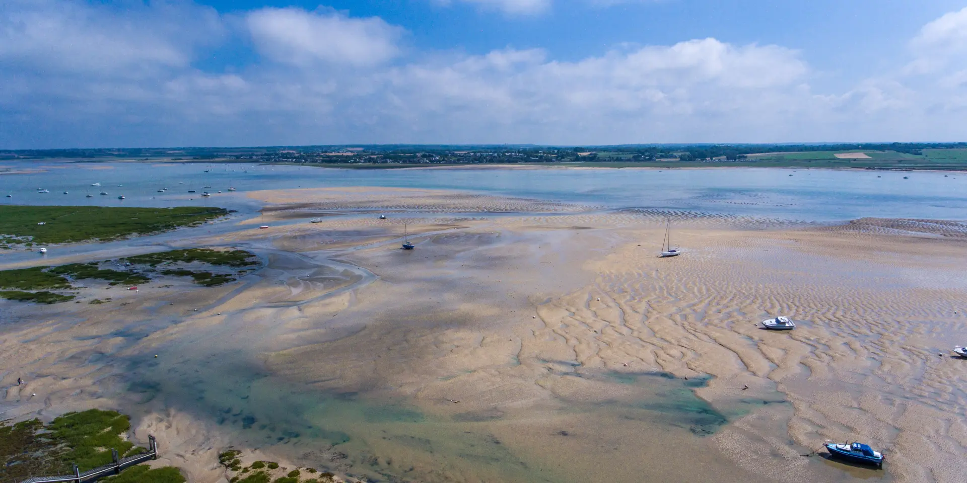 Beach with boats stranded at low tide