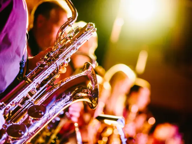 Plusieurs saxophonistes jouent en concert sous les projecteurs