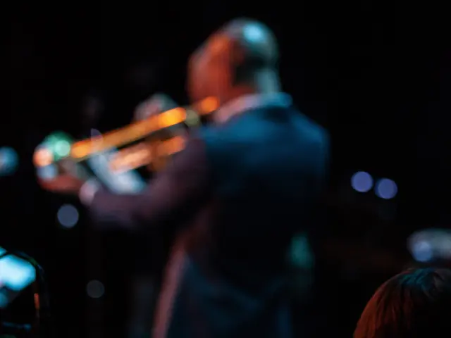 Un trompettiste joue sur scène avec un batteur en arrière-plan