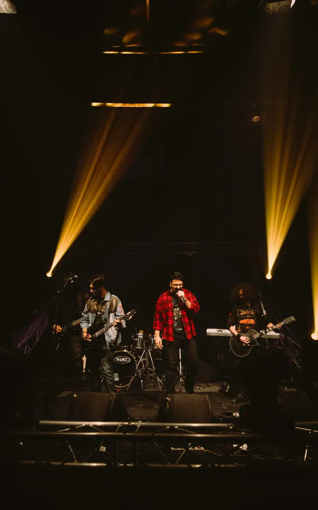 Groupe de musique jouant sur scène avec des projecteurs