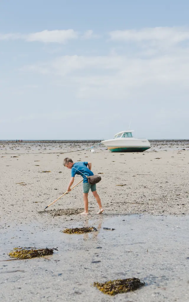 Ein Mann geht am Strand und stützt sich auf einen Stock