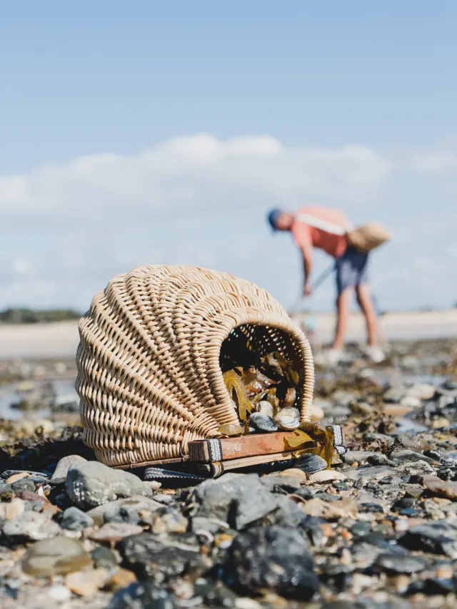 Two children climbing a rock by the sea